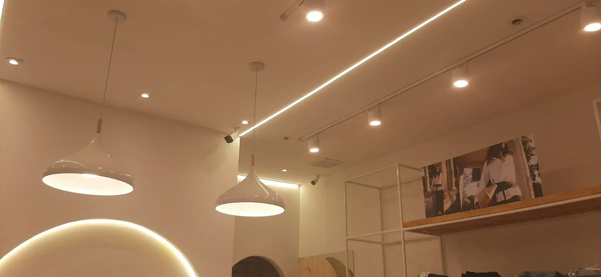 Iluminacion terminada con colgantes, spots y rieles en local comercial